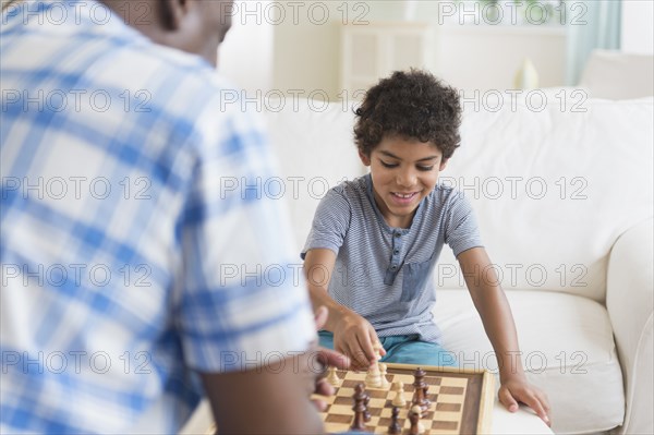 Boy playing chess with grandfather