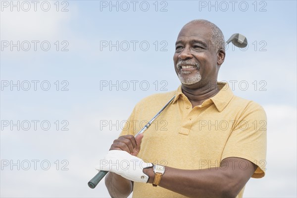 Black man playing golf outdoors