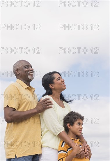 Three generations of family smiling outdoors