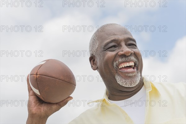 Black man throwing football outdoors