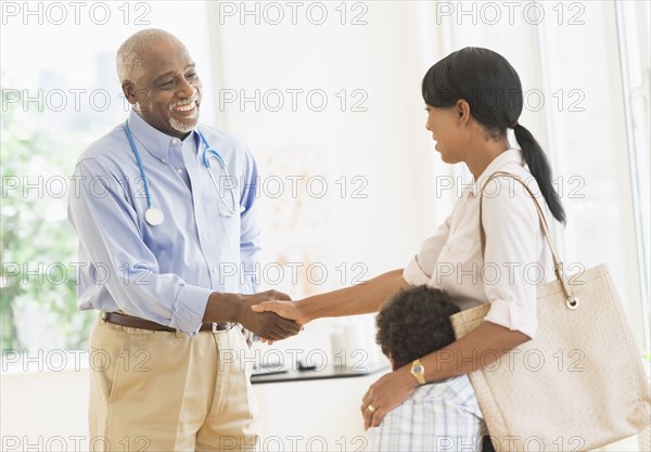 Doctor shaking mother's hand