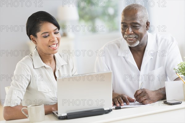 Black father and daughter using laptop