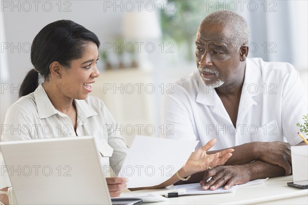 Black father and daughter using laptop