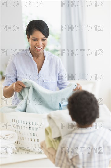 Mother and son folding laundry