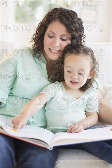 Mixed race mother reading with daughter