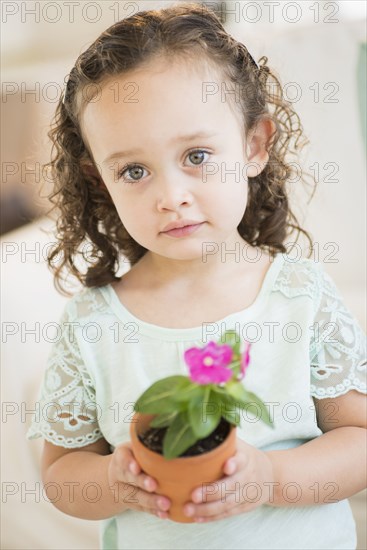 Mixed race girl holding flowerpot