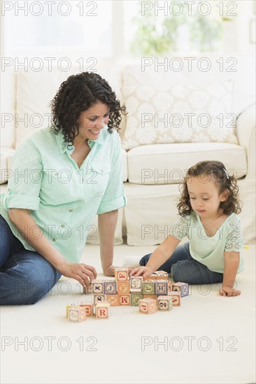 Mixed race mother and daughter playing with wooden blocks