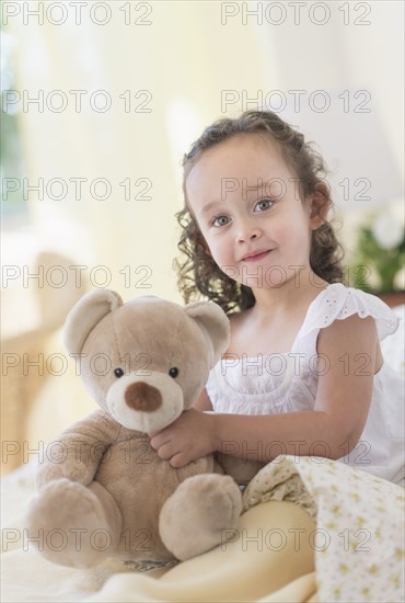 Mixed race girl holding teddy bear