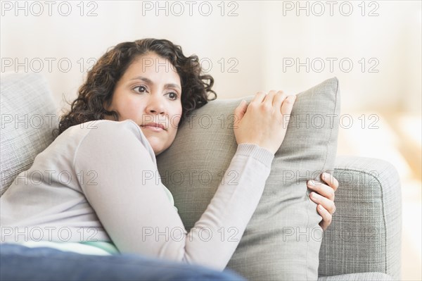 Hispanic woman relaxing on sofa