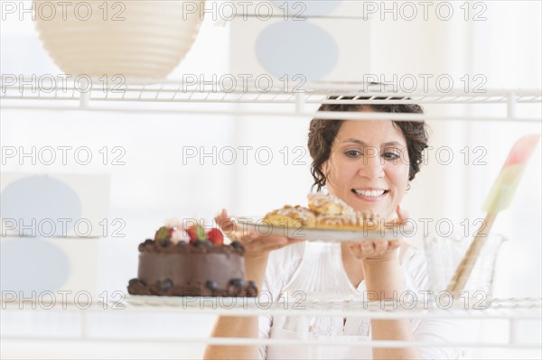 Hispanic baker holding fresh desserts