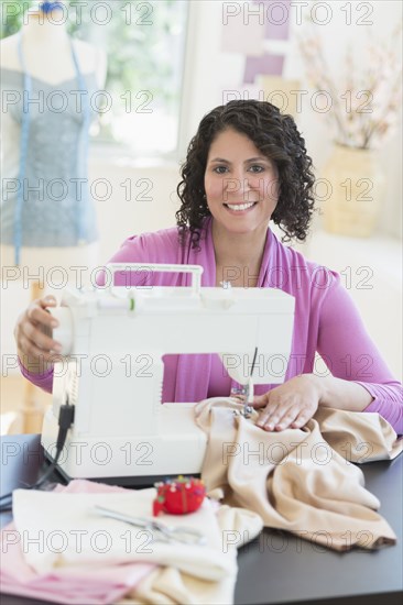 Hispanic dressmaker working at sewing machine