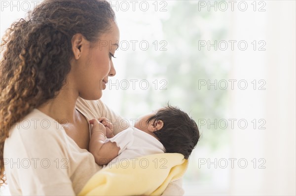 Hispanic mother holding newborn baby