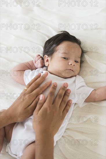 Hispanic mother cradling baby