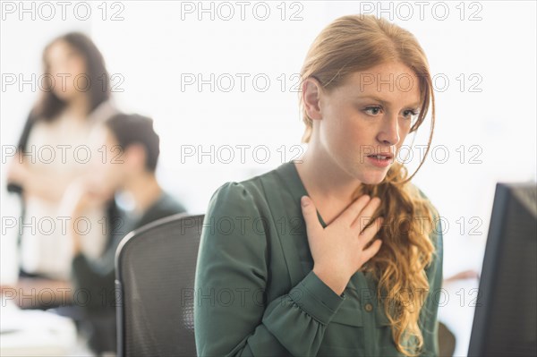Businesswoman gasping at computer in office