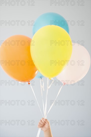 Korean girl holding bunch of balloons