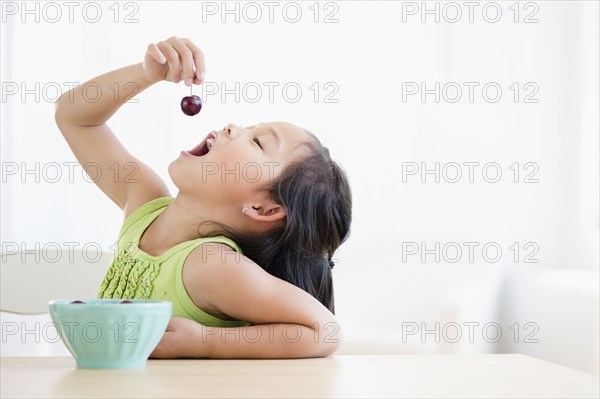Korean girl eating bowl of fruit