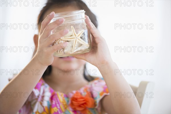 Korean girl examining starfish in jar