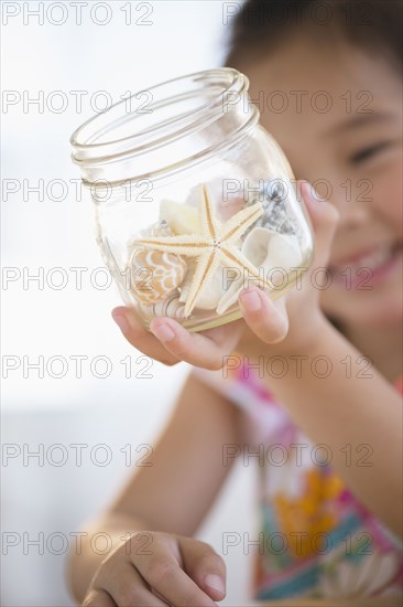 Korean girl examining starfish in jar