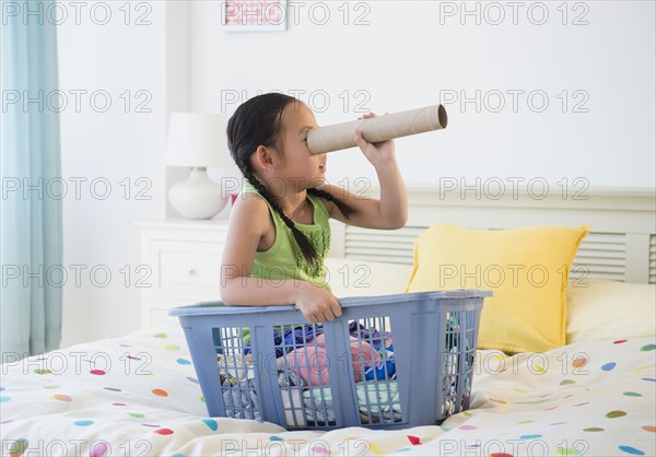 Korean girl looking through cardboard tube