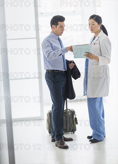 Doctor and businessman talking in hospital