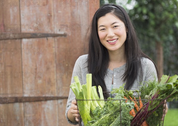 Korean woman carrying basket of vegetables