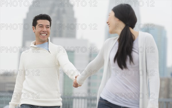 Couple holding hands in city