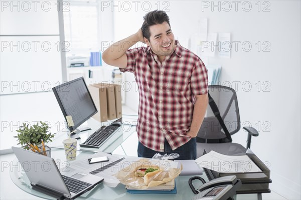 Mixed race businessman smiling at desk