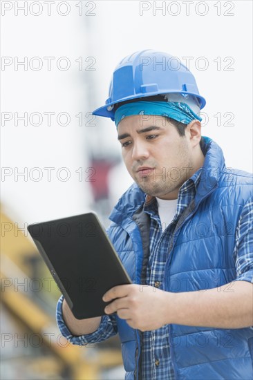 Mixed race engineer using digital tablet at construction site