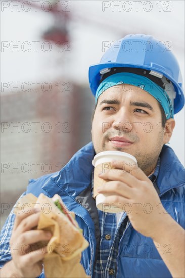 Mixed race worker eating lunch on construction site