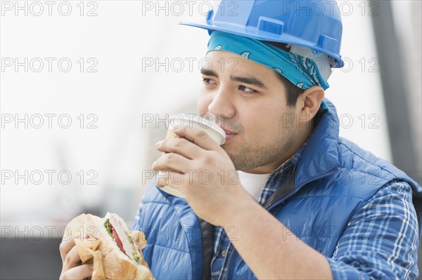Mixed race worker eating lunch on construction site