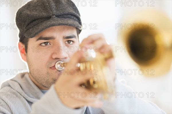 Mixed race man playing trumpet