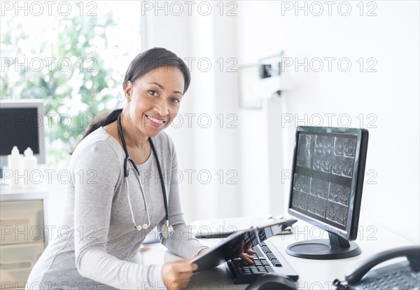 African American doctor holding clipboard in office