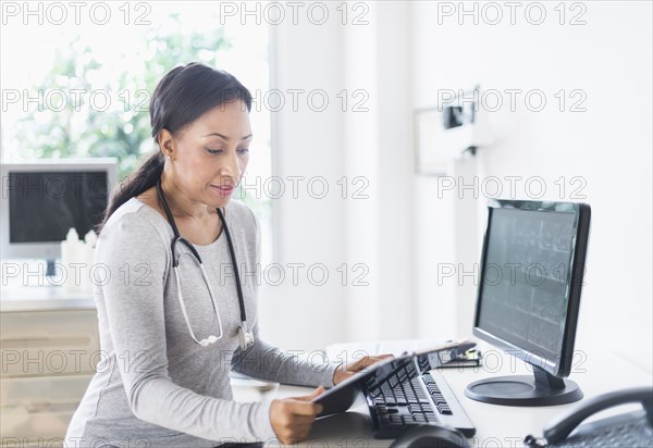 African American doctor looking down at clipboard