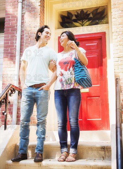 Couple standing on front stoop with house key