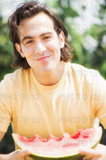 Caucasian man eating watermelon outdoors