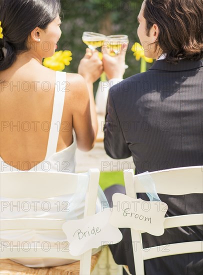 Newlywed couple toasting champagne glasses at reception