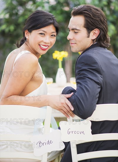 Newlywed couple sitting together at wedding reception