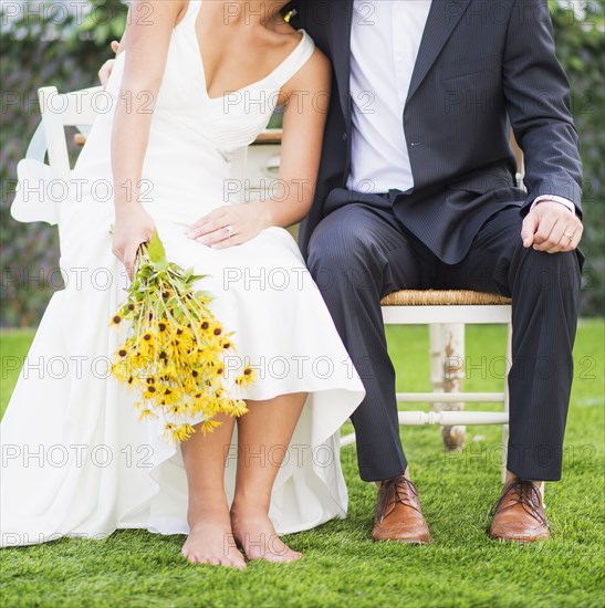 Newlywed couple sitting outdoors