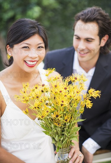 Newlywed couple holding bouquet