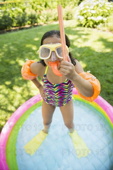 Mixed race girl wearing snorkeling gear in wading pool