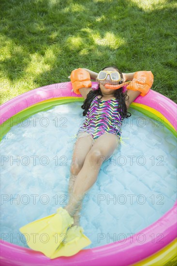 Mixed race girl wearing snorkeling gear in wading pool