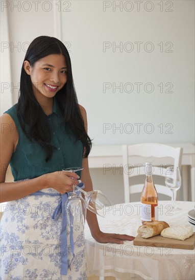 Chinese woman setting table in dining room