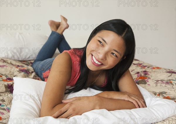 Chinese woman smiling on bed