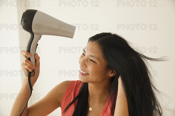 Chinese woman blow drying her hair