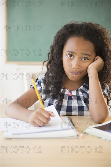 Mixed race student working in classroom