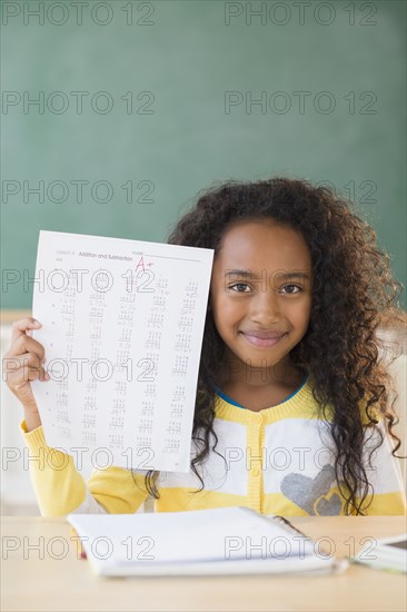 Mixed race student showing off A plus grade in classroom