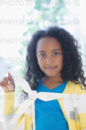 Mixed race girl with model wind turbine