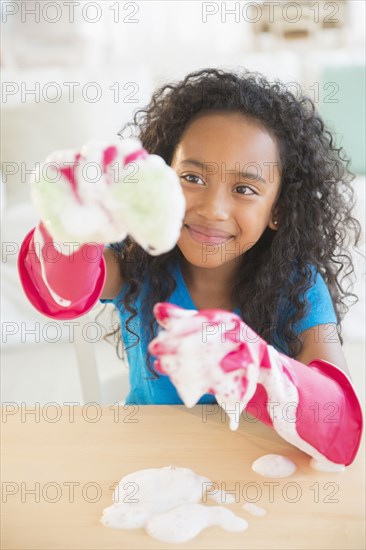 Mixed race girl washing dishes