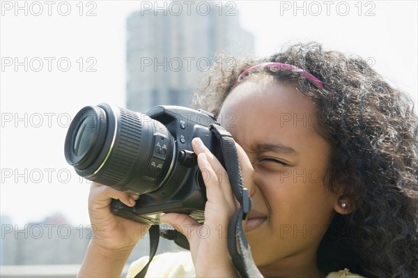 Mixed race girl taking pictures outdoors