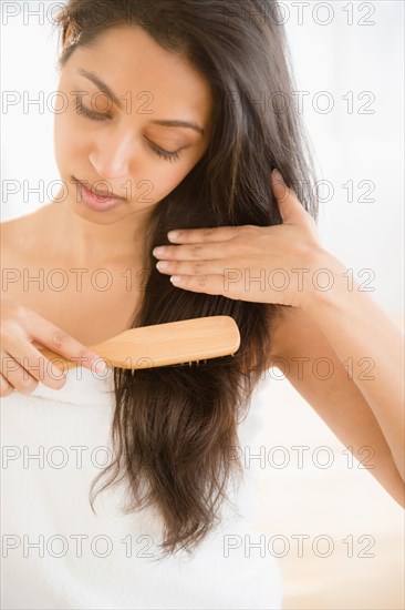 Close up of Asian woman brushing hair